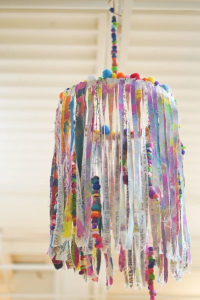 HOPES + DREAMS CHANDELIER |  Acrylic Paint on Canvas and Polymer Clay Beading on Wire | Caregivers annually write their hopes and dreams for their children on a strip of canvas. Students paint the canvas and make the accessories. This collaborative installation brings families, children, and educators together to celebrate what the upcoming school year will bring.