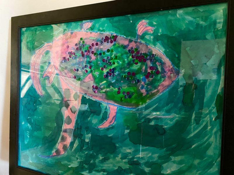 RAINBOW FISH | Oil Pastel, Liquid Watercolor, and Mixed Media on Poster Board | Two students selected to participate in our Child-Centered Creativity (C3) program, an arts enrichment program designed for students with specific social-emotional needs or challenges, were inspired by the classroom Beta fish. Upon reading “Rainbow Fish” and taking turns, these artists collaborated peacefully to create their very own rainbow fish.