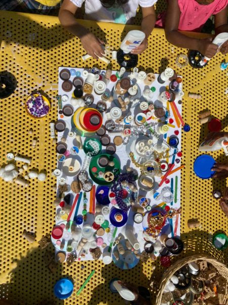 STICKY TOWN | Recyclable Materials, Mixed Media Assemblage | Students enjoyed digging through recycled treasures and arranging them, playing with them, and adhering them to each other and this board. They enhanced their ability to think critically while arranging, stacking, and experimenting with size, balance, and weight, while promoting creativity. Loose parts require a great deal of imagination to become other things – like towns!